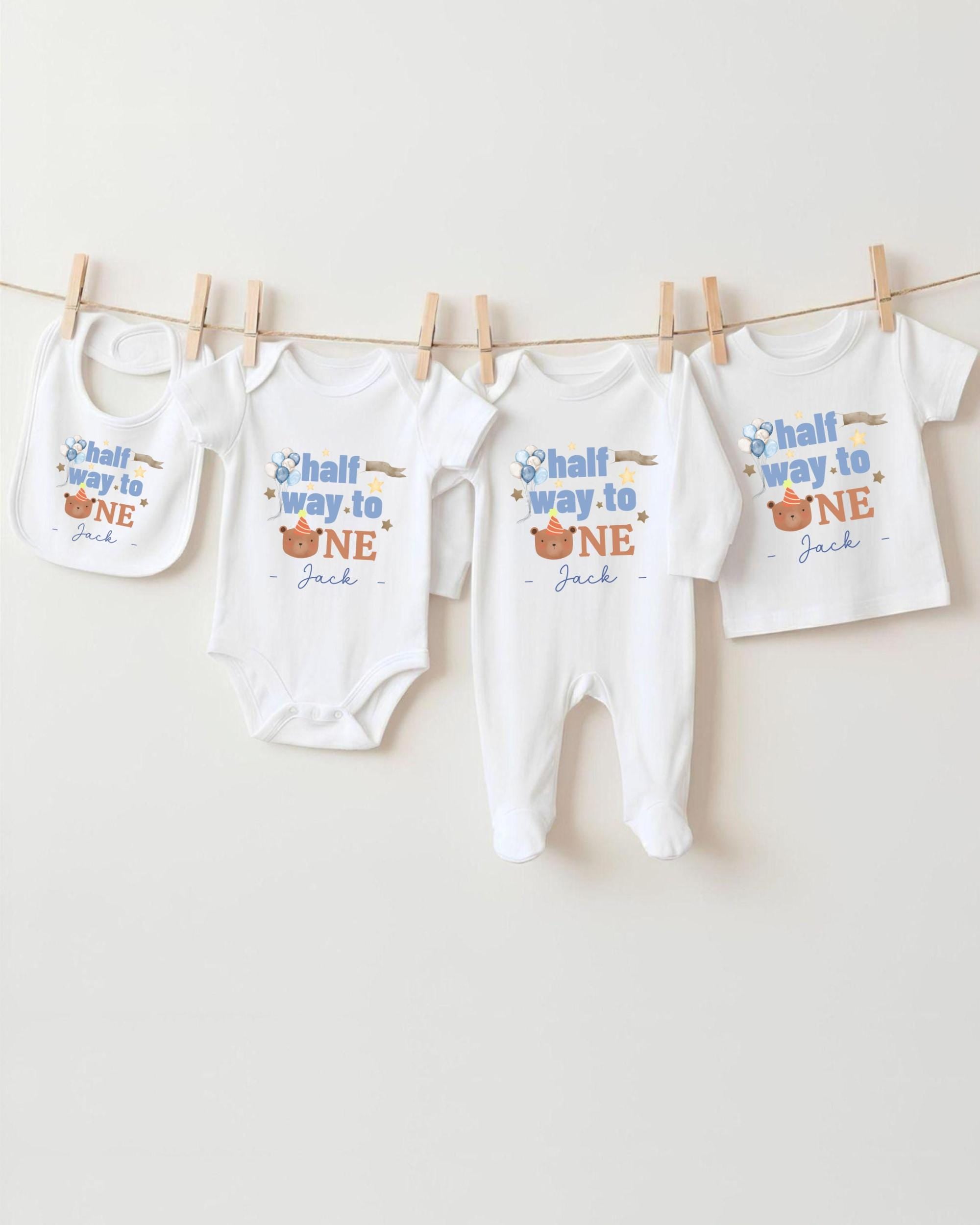 A collection of baby clothes, including onesies and pajamas, hanging on a clothesline.