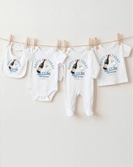 A collection of white baby clothes, including onesies and bibs, hanging on a clothesline.