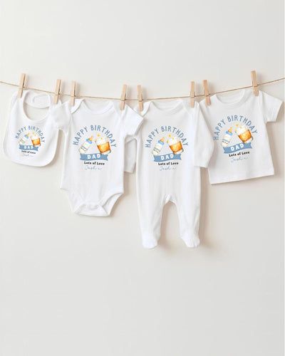 A collection of white baby clothes, including onesies and bibs, hanging on a clothesline.