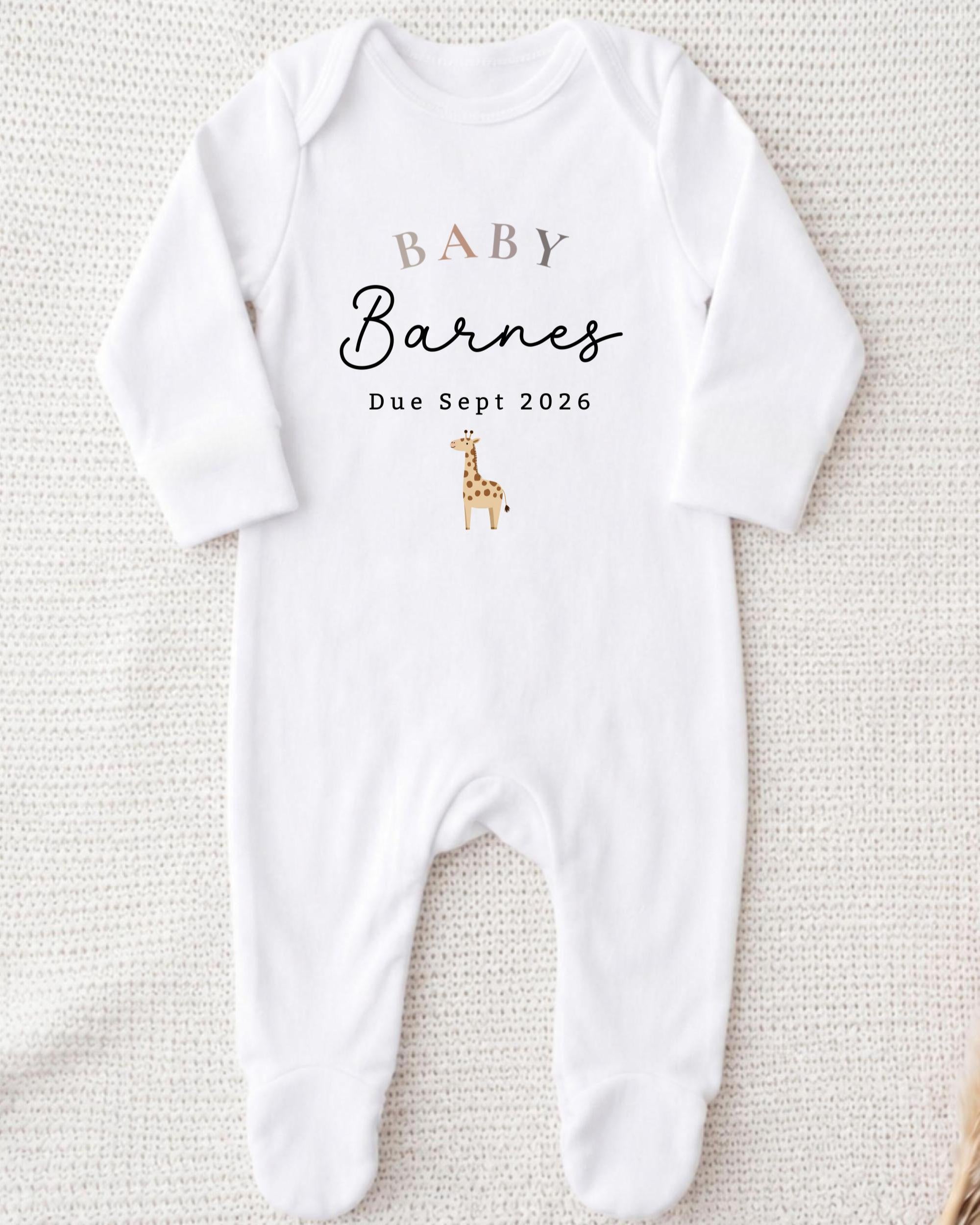 A white onesie with text and a small giraffe graphic printed on it.