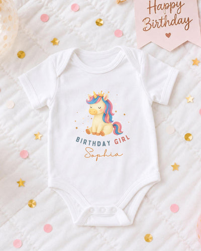 A white bodysuit with a unicorn graphic and the text "Birthday Girl Sophia" printed on it, surrounded by confetti and a birthday banner.