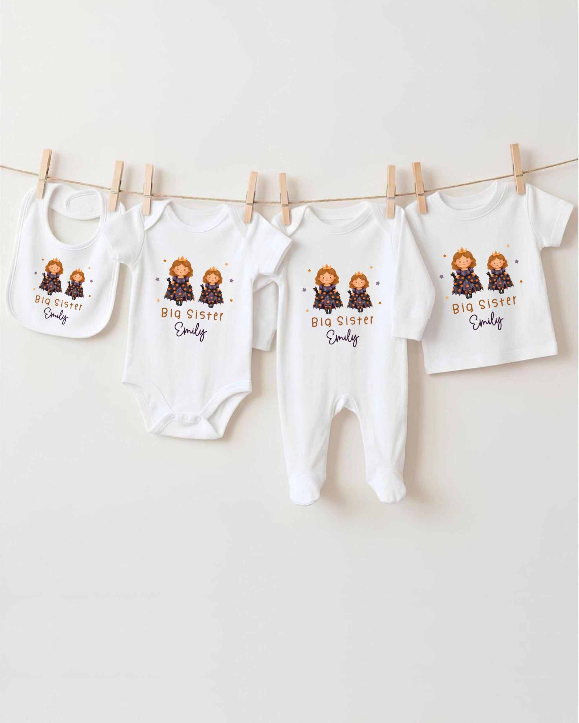 A row of four white baby clothes with the text "Big Sister Emily" printed on them, hanging on a clothesline.