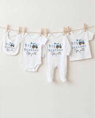 A row of four white baby clothes with blue designs, each labeled with the name "Big Brother Matt".