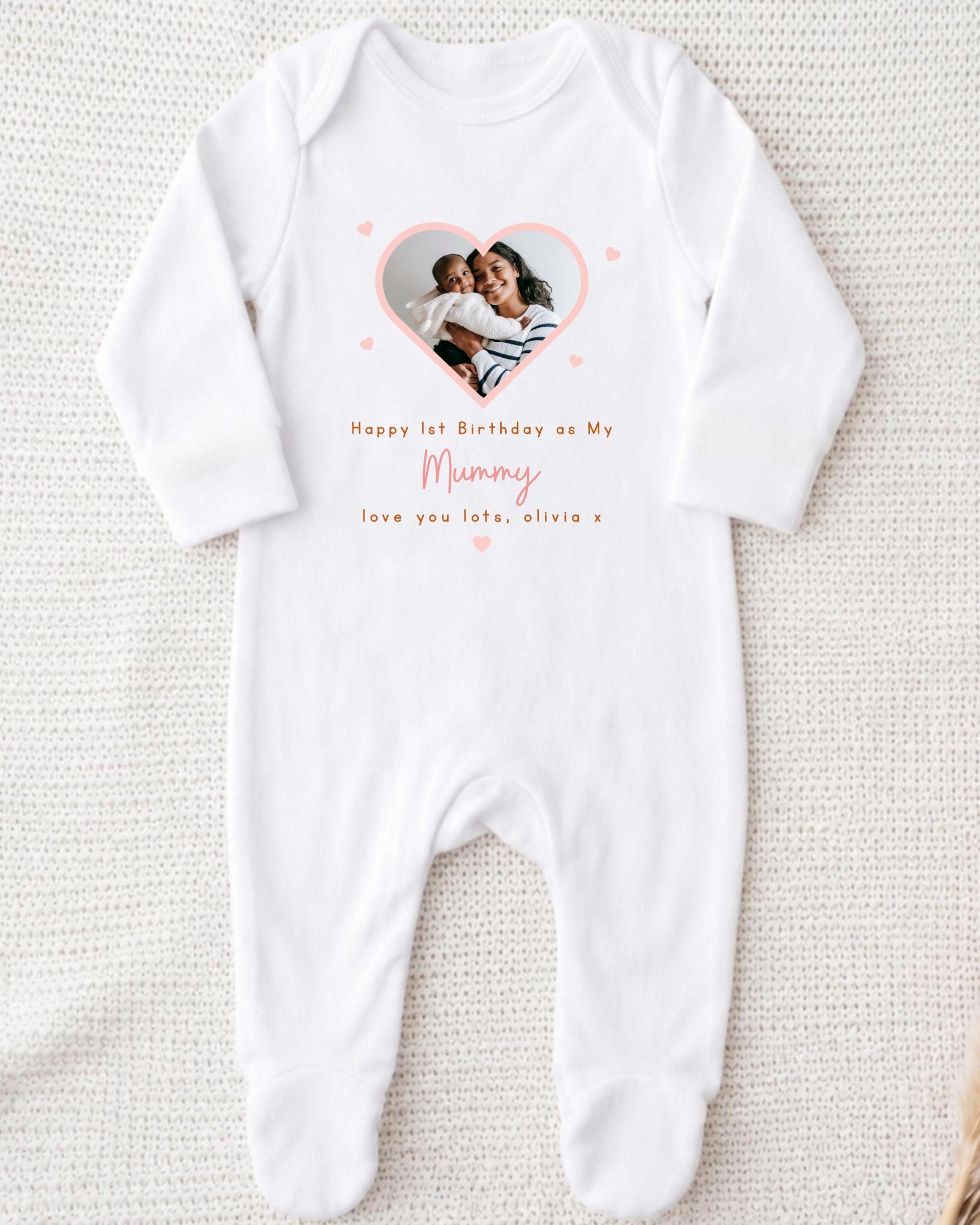 A white onesie with a photo of a mother and child inside a heart shape, along with the text "Happy 1st Birthday as My Mummy, love you late, Olivia x".