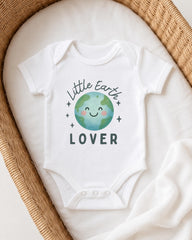A white onesie with a cartoon image of the Earth and the text "Little Earth Lover" printed on it, placed in a woven basket.