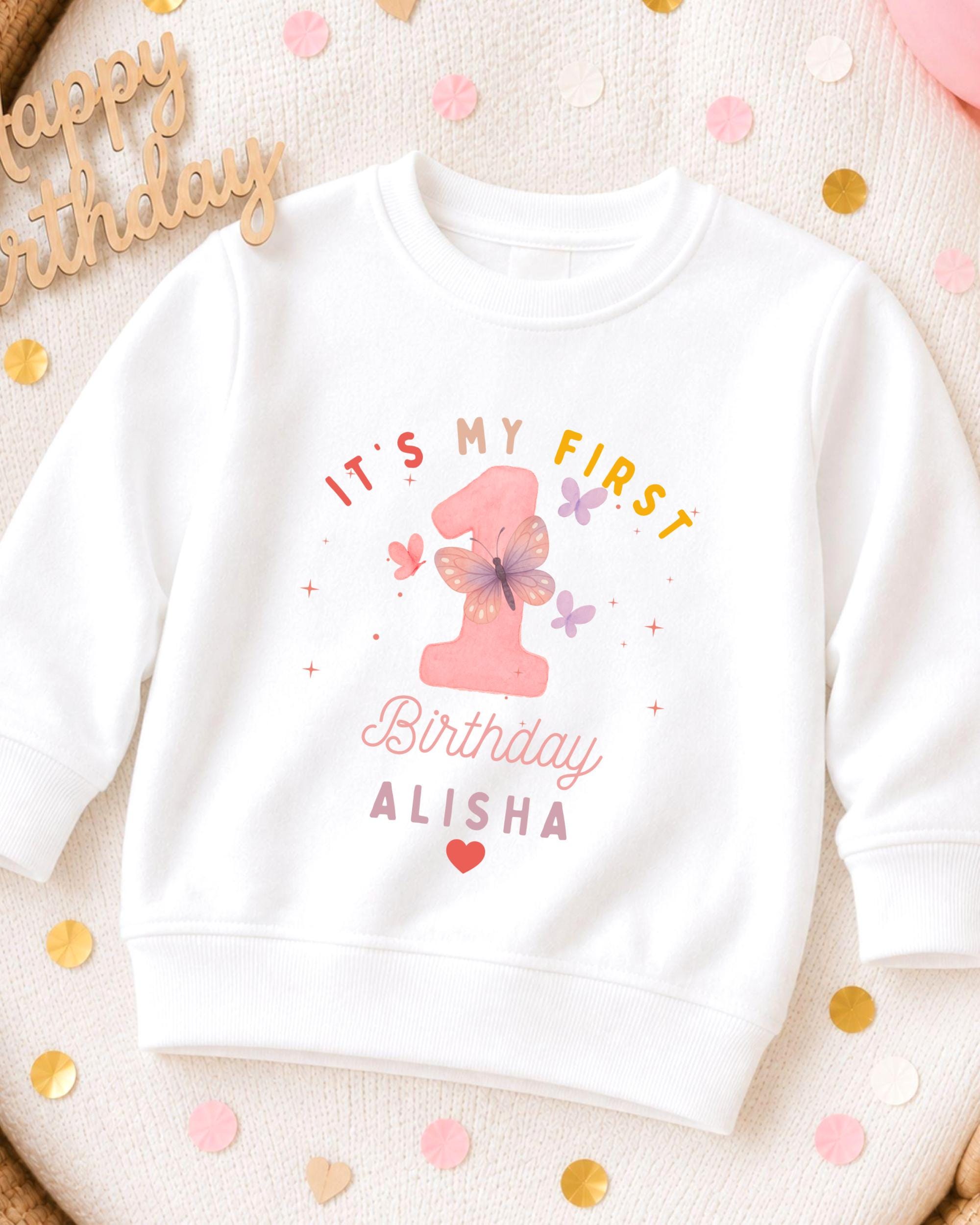 A white sweatshirt with a personalized birthday message printed on it, surrounded by confetti.