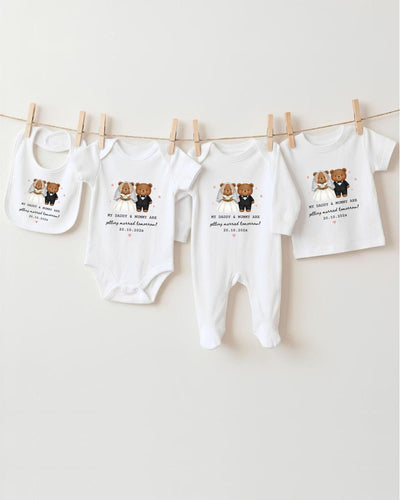 a collection of baby clothes, including bodysuits and bibs, hanging on a clothesline.