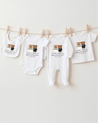 a collection of baby clothes, including onesies and bibs, hanging on a clothesline.