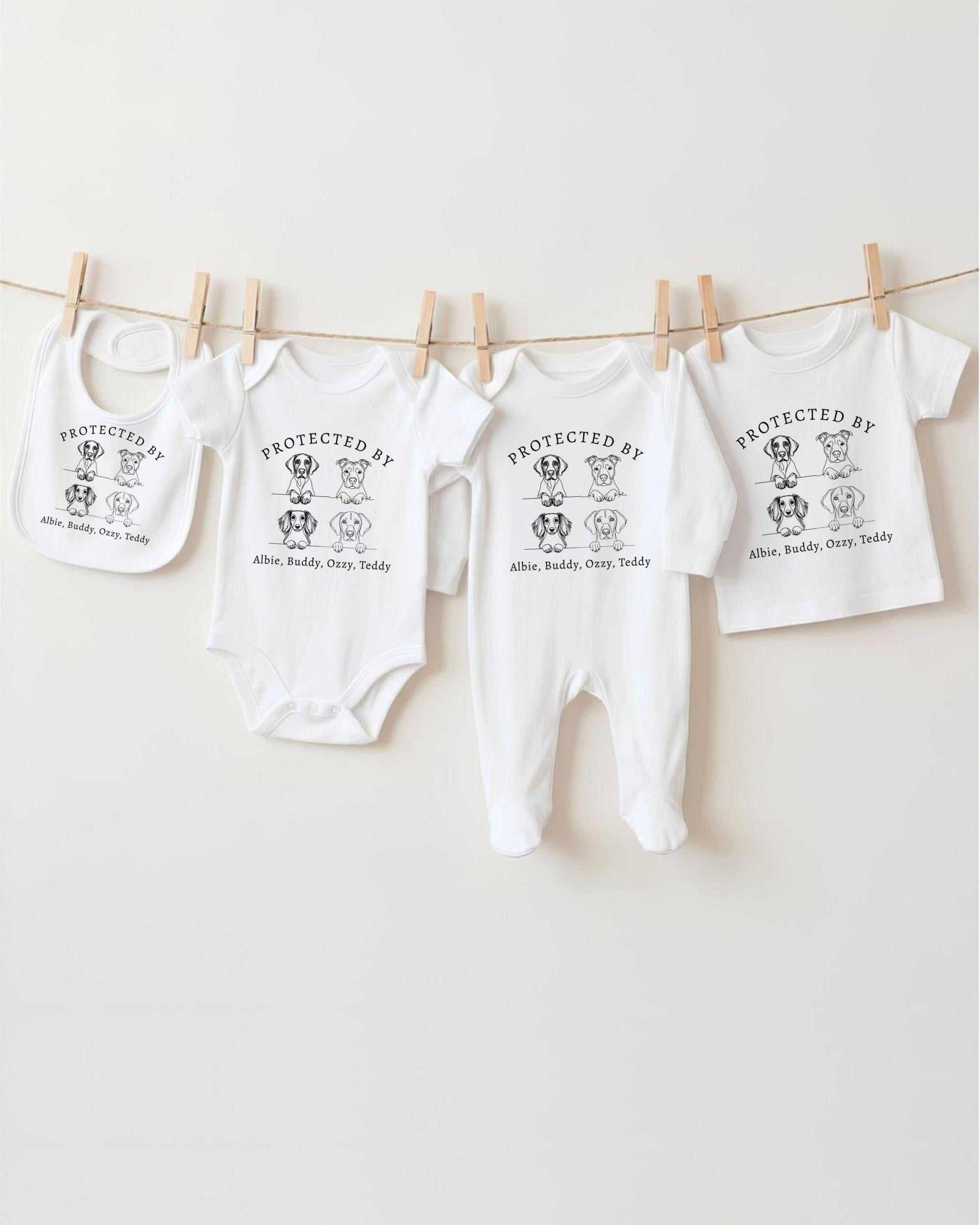 A row of four white baby clothes, including onesies and bibs, hanging on a clothesline.