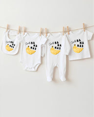 a collection of baby clothes, including onesies and bibs, hanging on a clothesline.