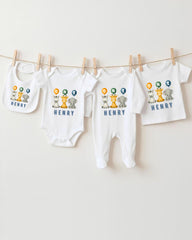 A collection of baby clothes, including onesies and bibs, hanging on a clothesline.