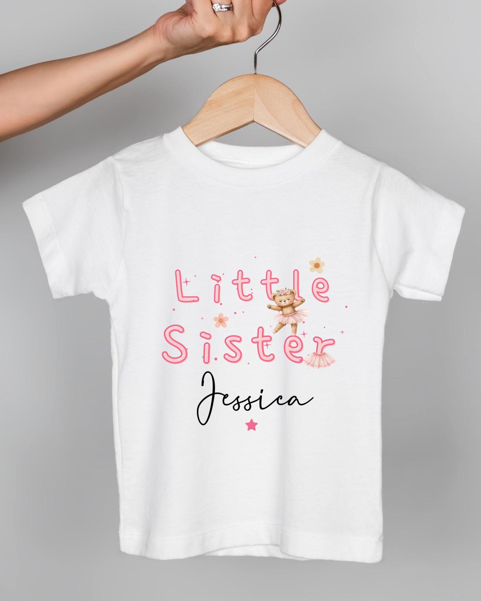 A white t-shirt with pink text and a small illustration of a girl.