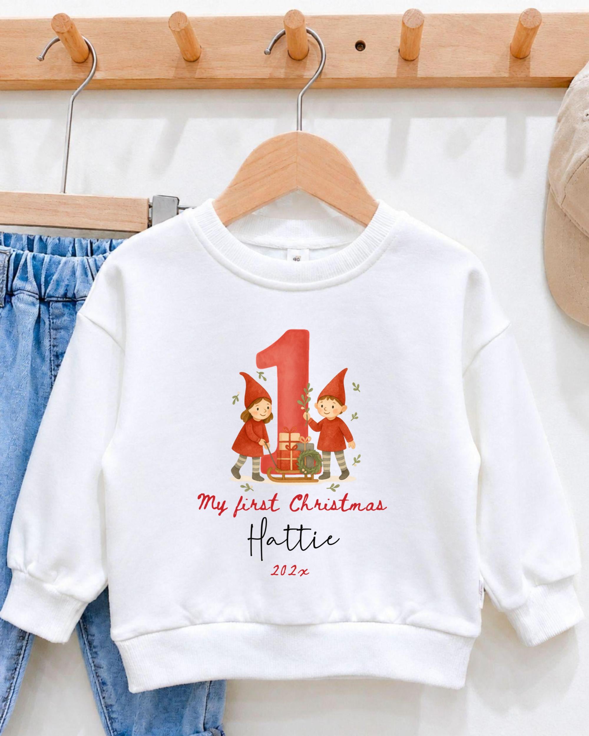 A white sweatshirt with a red number one and two dwarfs printed on it, hanging on a wooden hanger.