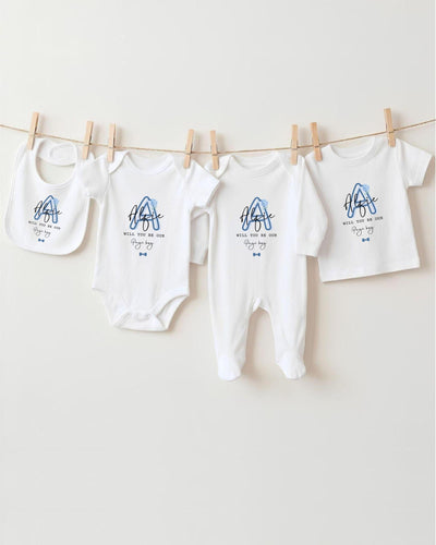 A row of white baby clothes, including bodysuits and bibs, hanging on a clothesline.
