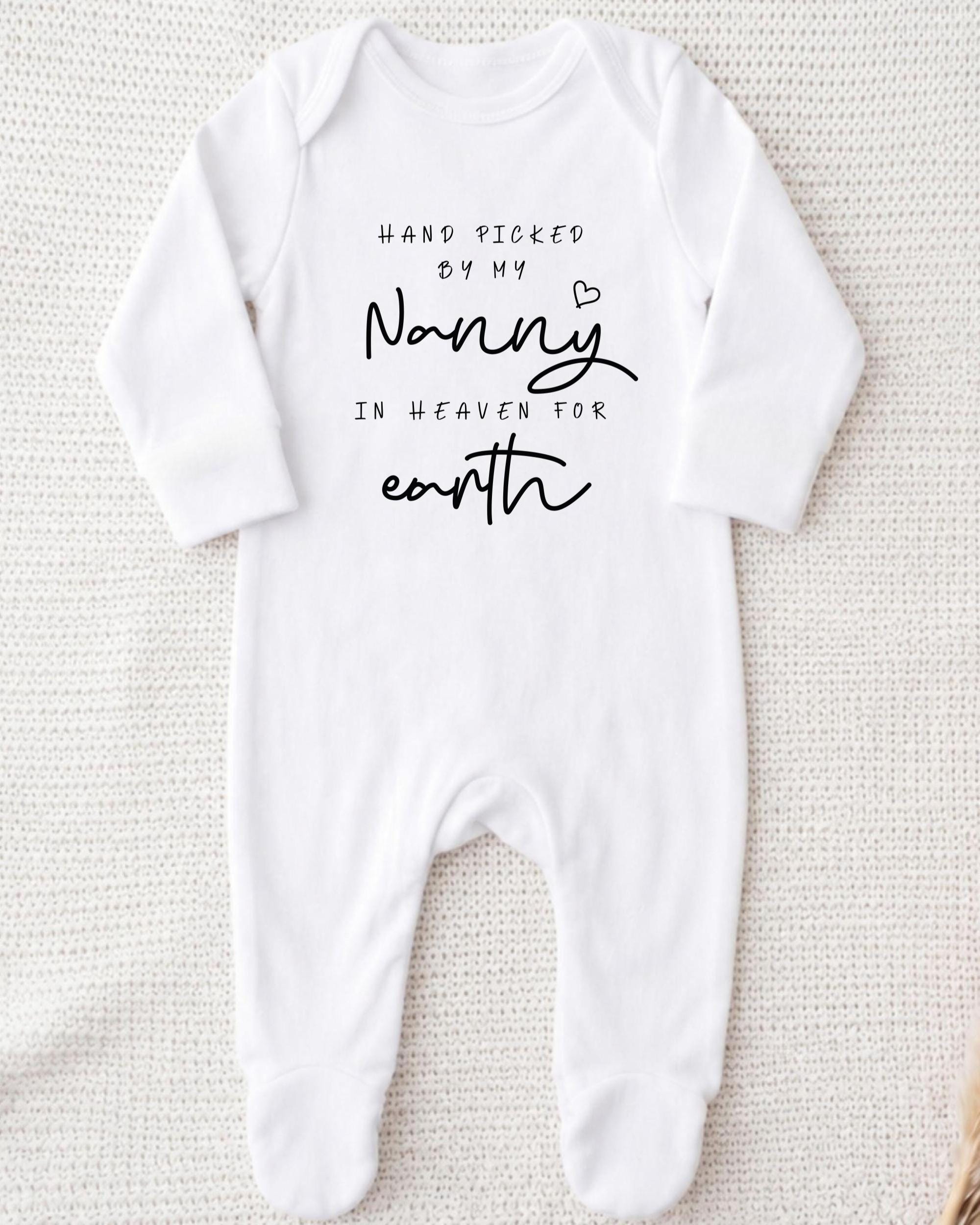 A white onesie with black text that reads "Hand picked by my Nanny in Heaven for earth".