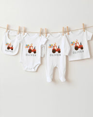 A collection of baby clothes, including onesies and bibs, are hanging on a clothesline.