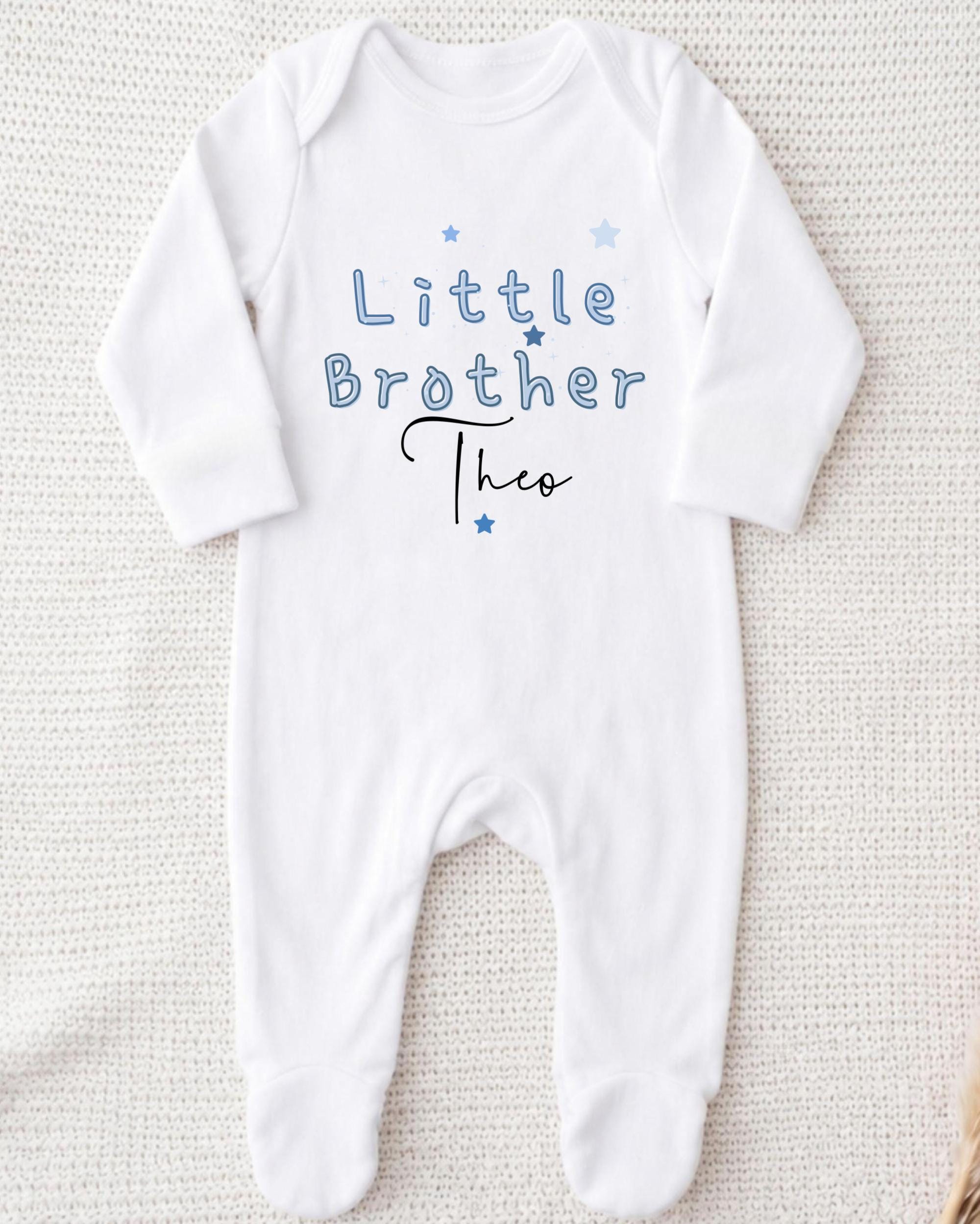A white onesie with the text "Little Brother Theo" printed on it.