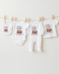 A collection of baby clothes, including onesies and bibs, hanging on a clothesline.