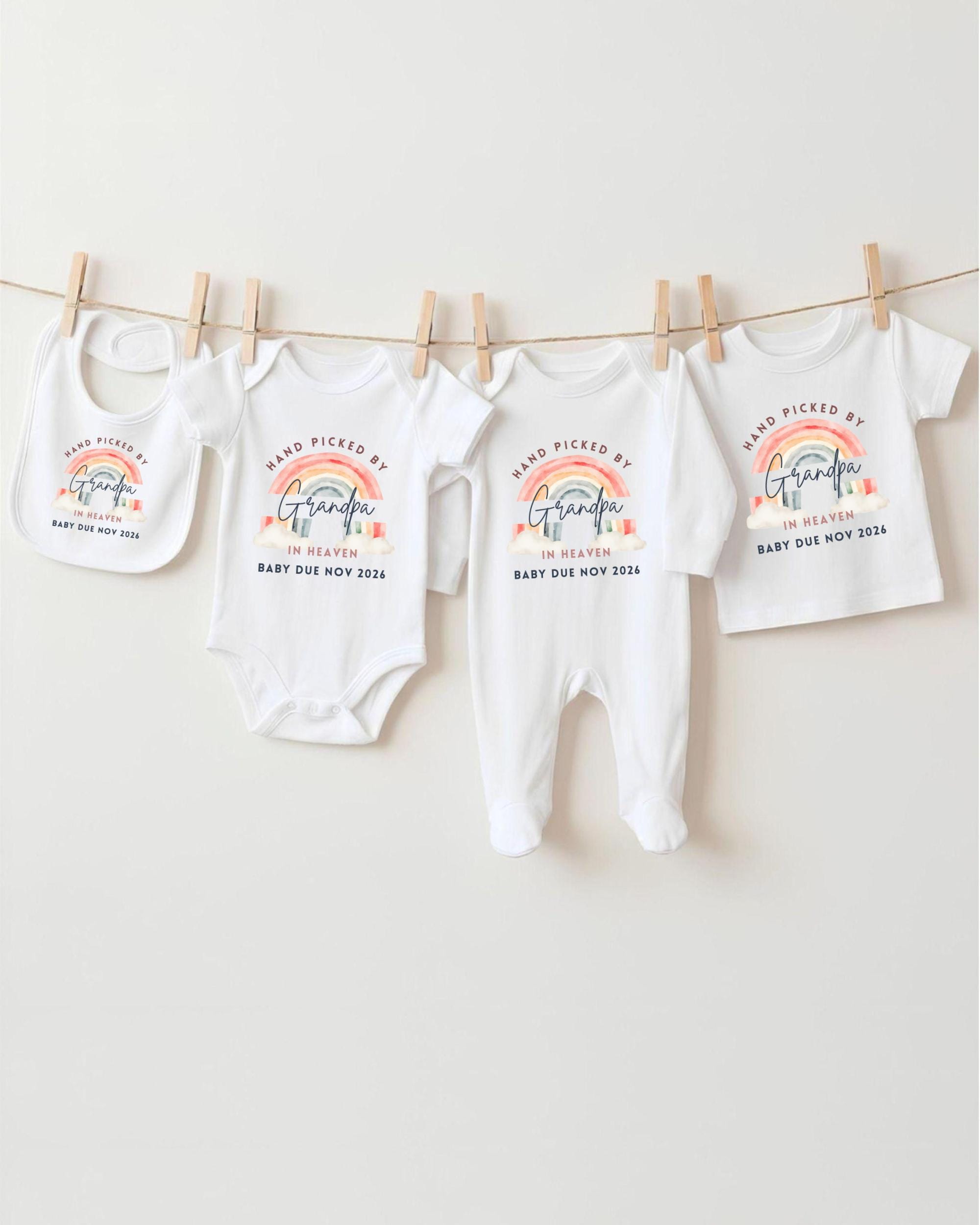 A collection of baby clothes, including onesies and bibs, hanging on a clothesline.