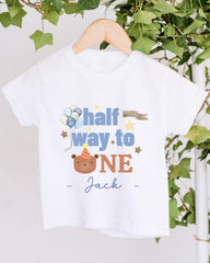 A white t-shirt with a graphic design featuring a bear wearing a party hat and balloons, along with the text "half way to one" and "Jack" printed on it.