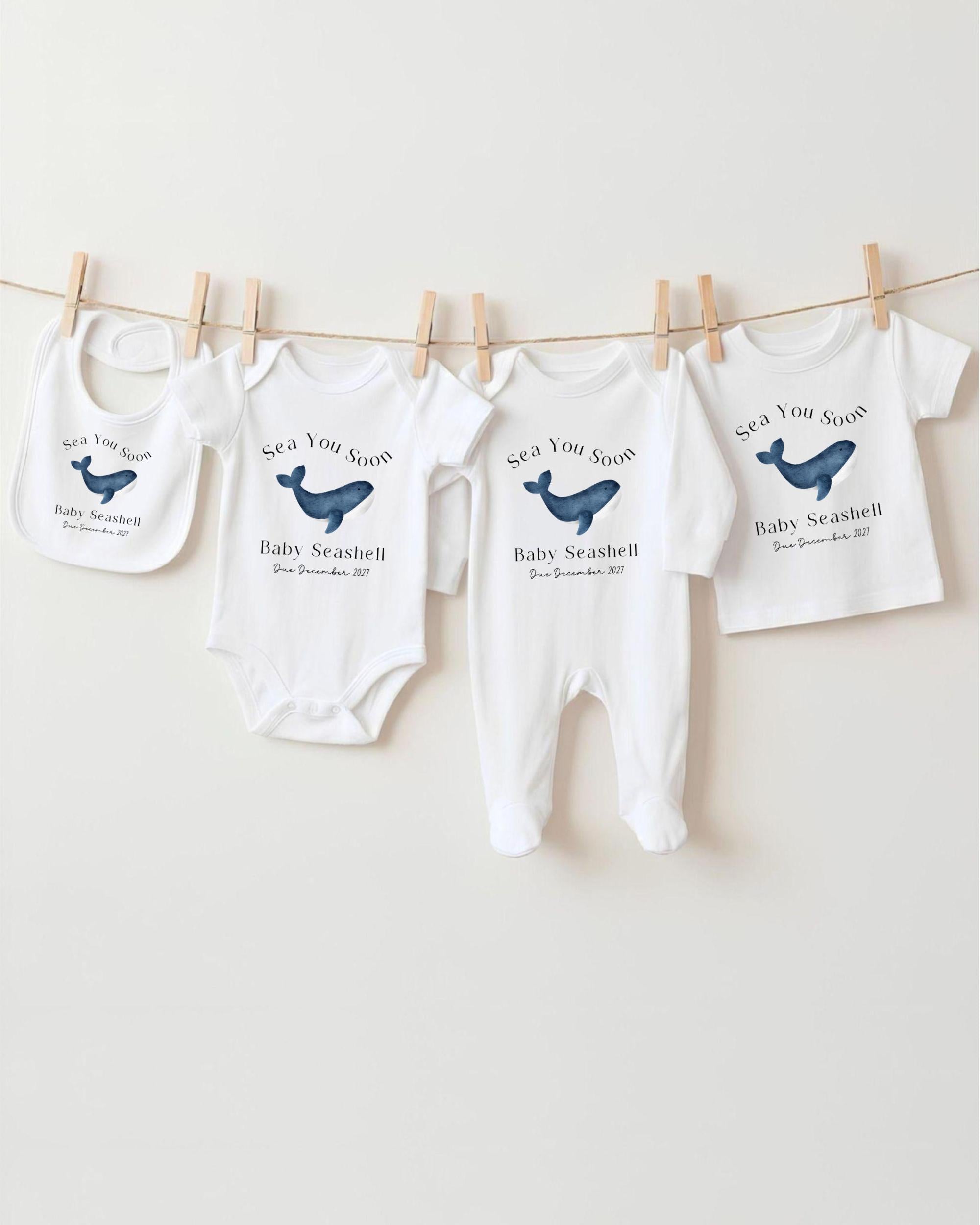 a collection of baby clothing items, including onesies and pajamas, hanging on a clothesline.