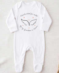 A white onesie with a graphic design and text on it.