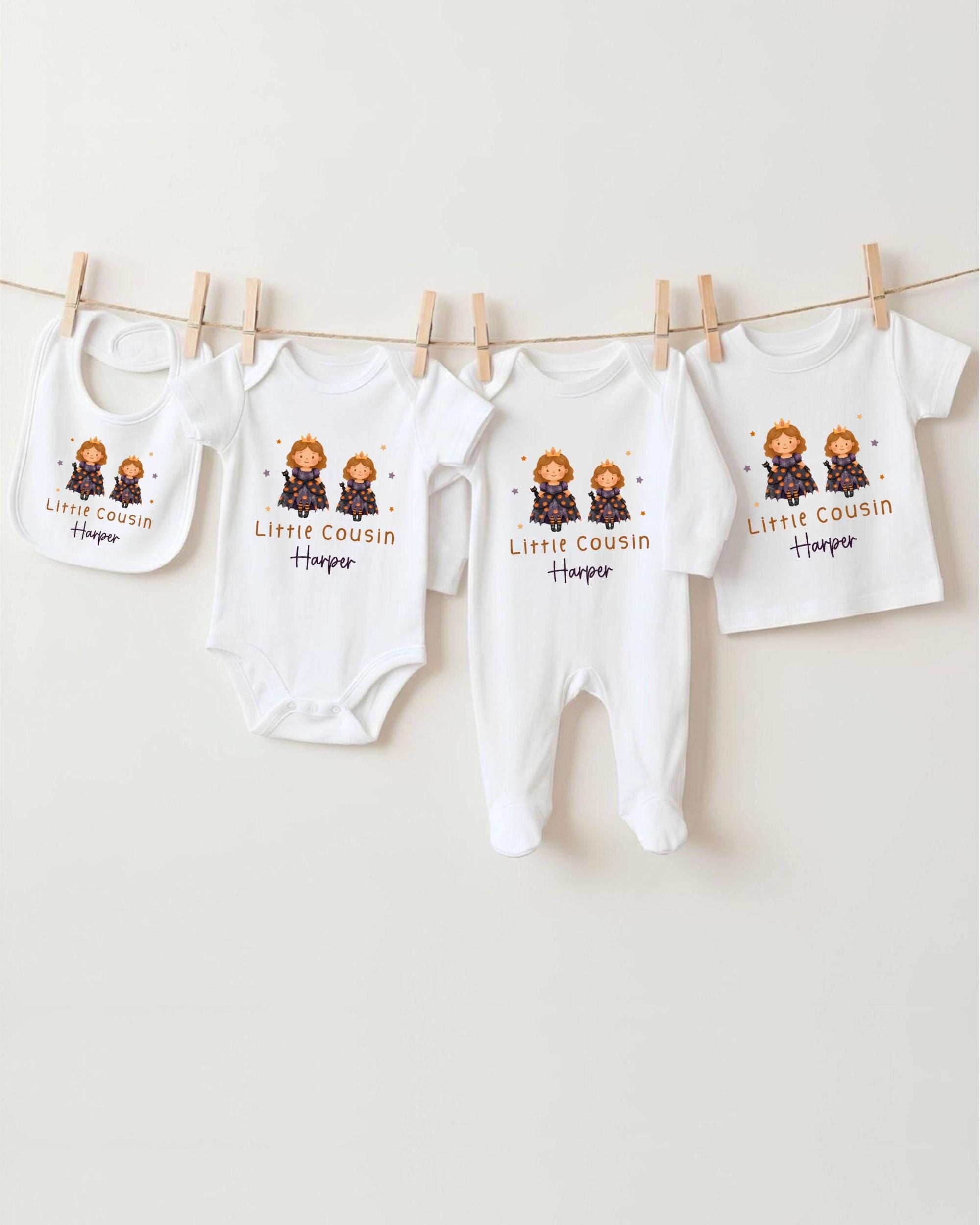 A row of white baby clothes with the name "Little Cousin Harper" printed on them, hanging on a clothesline.