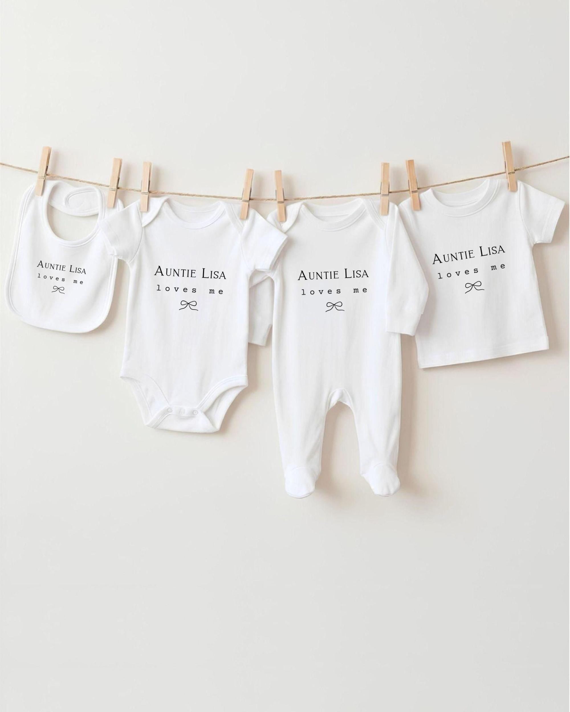 A collection of white baby clothes, including onesies and pajamas, hanging on a clothesline.