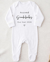 A white onesie with the text "Second Grandbaby Due Sept 2028" printed on it.