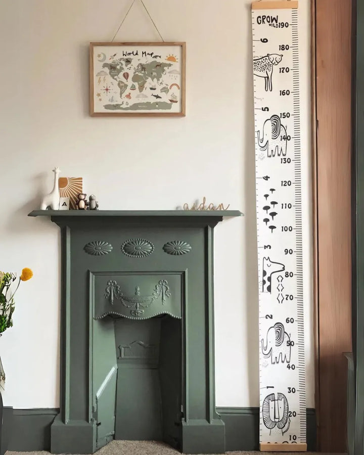 a green fireplace in a living room next to a ruler