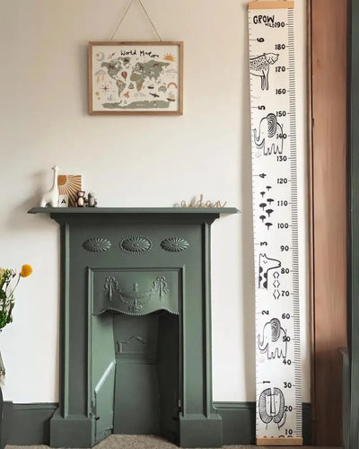 a green fireplace in a living room next to a ruler