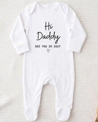 A white onesie with the text "Hi Daddy See You in 2027" printed on it.