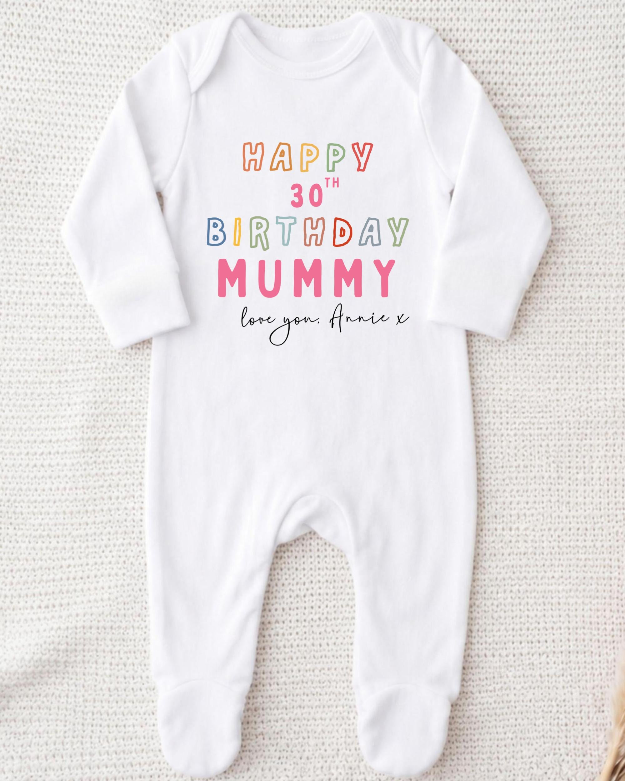 A white onesie with text printed on it, likely a birthday outfit for a baby.