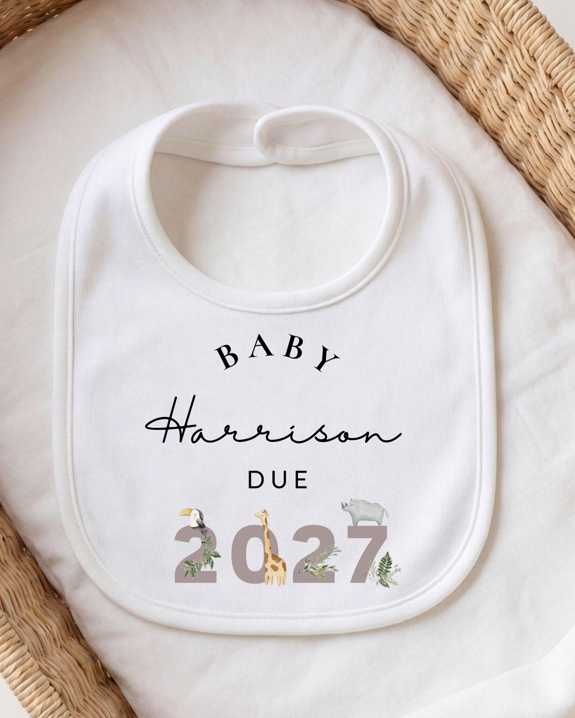 A white baby bib with personalized text and a graphic design.