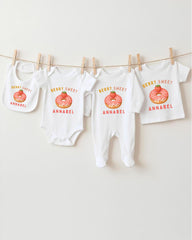 a collection of baby clothes, including onesies and bibs, hanging on a clothesline.