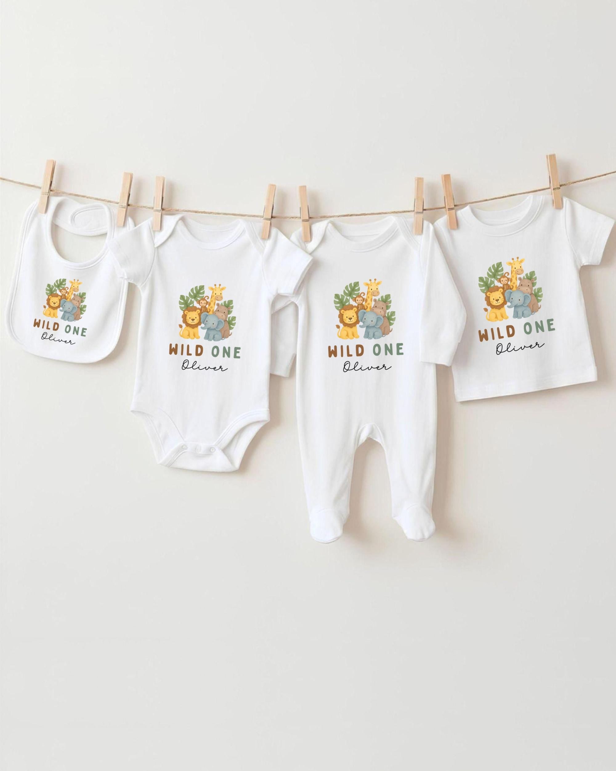 A collection of baby clothes, including onesies and bibs, hanging on a clothesline.