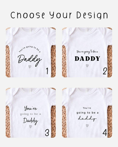 Four white Baby Vest designs with black pregnancy announcement messages for Daddy in different script and block styles and small outlined hearts.