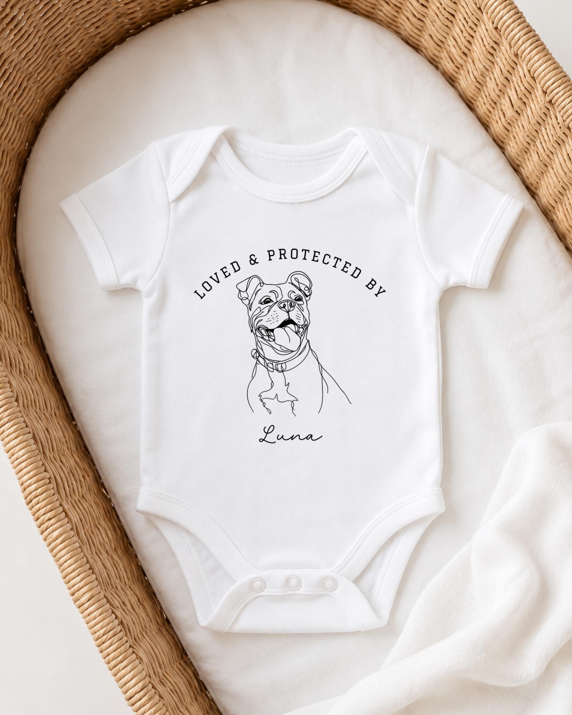 A white onesie with a black illustration of a dog and the text "LOVED & PROTECTED BY Luna" printed on it.