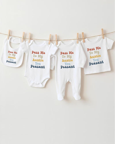 A row of four white baby clothes hanging on a clothesline, each with a different message printed on it.