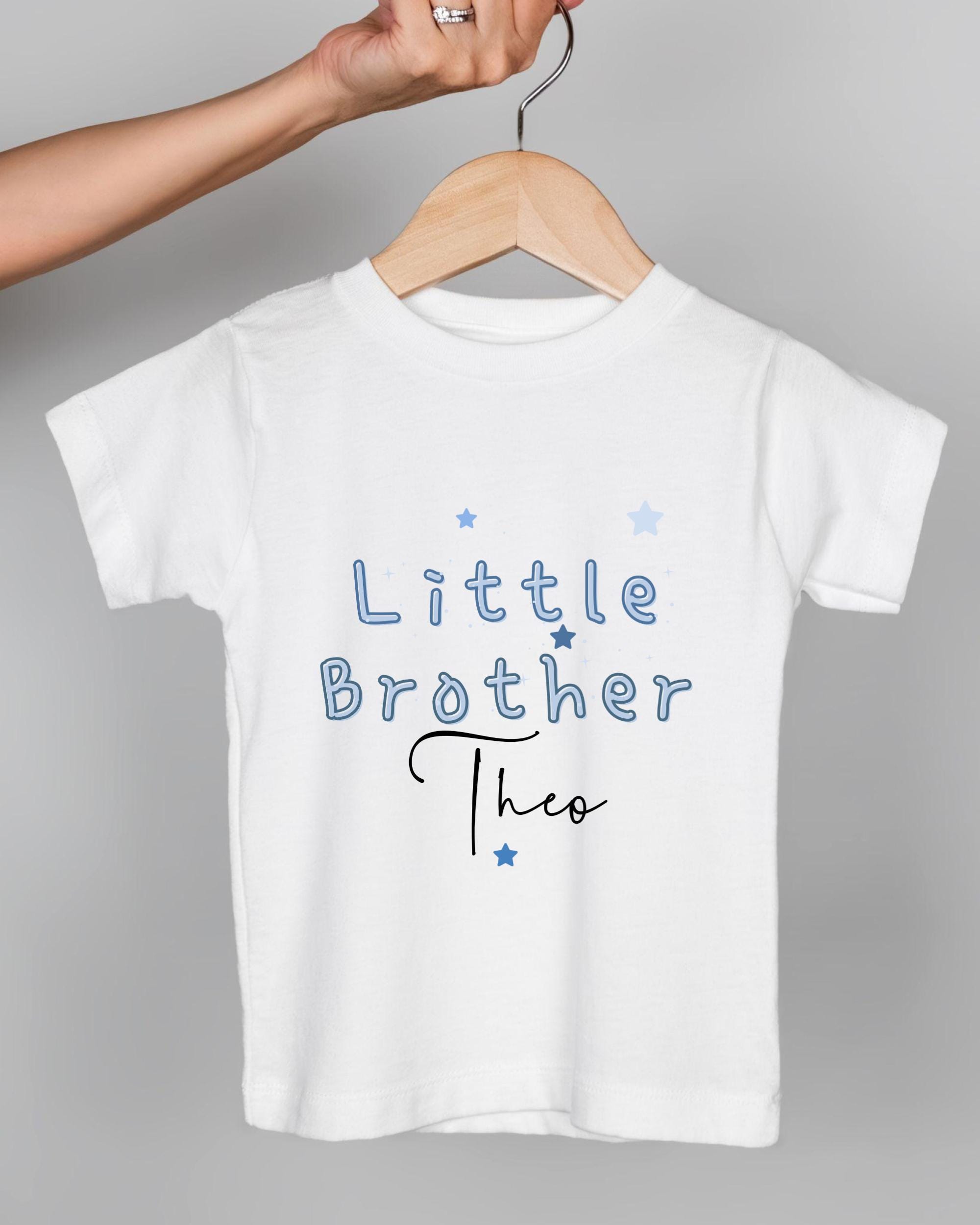 A white t-shirt with the text "Little Brother Theo" printed on it.