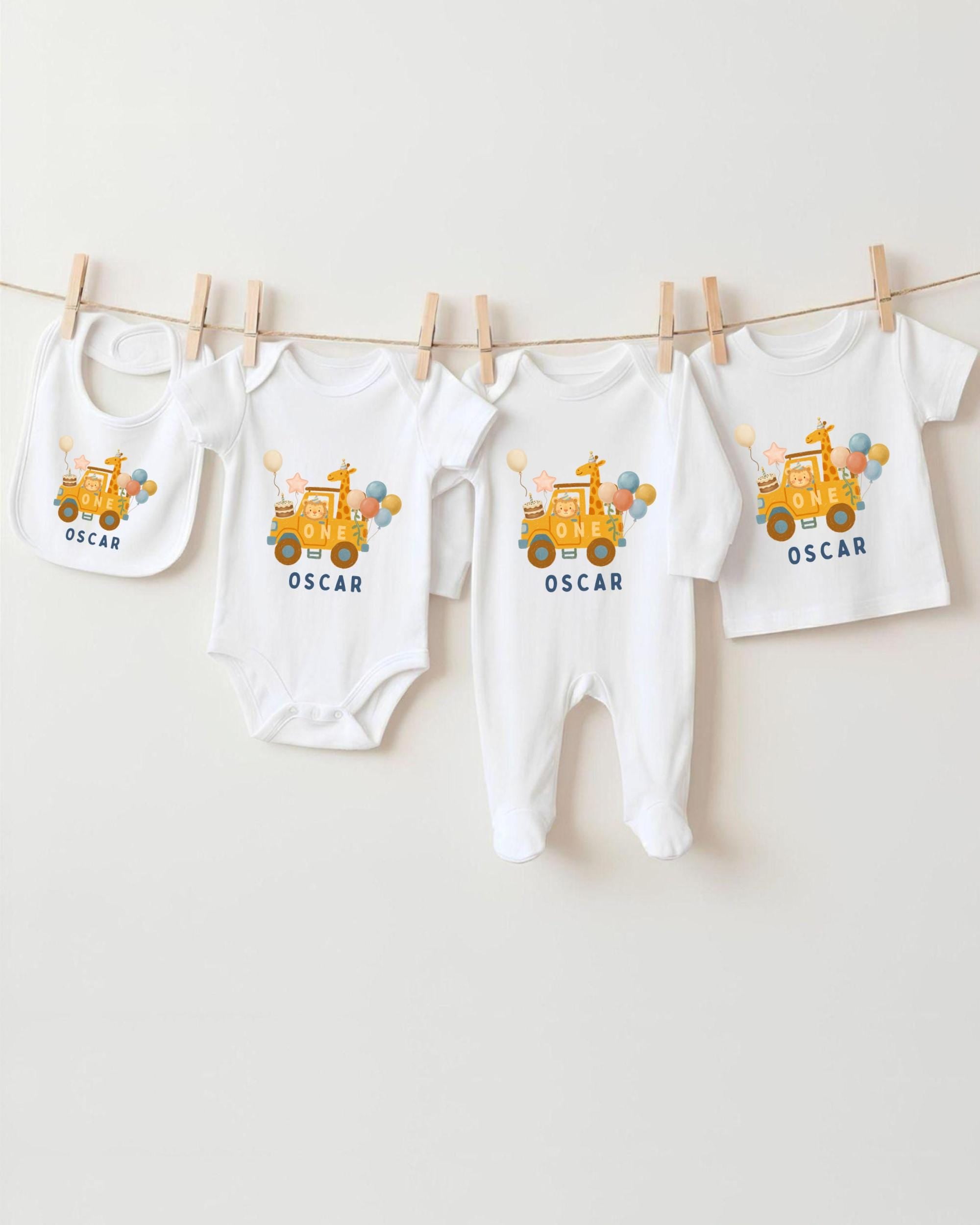 A collection of baby clothes, including onesies and bibs, are hanging on a clothesline.