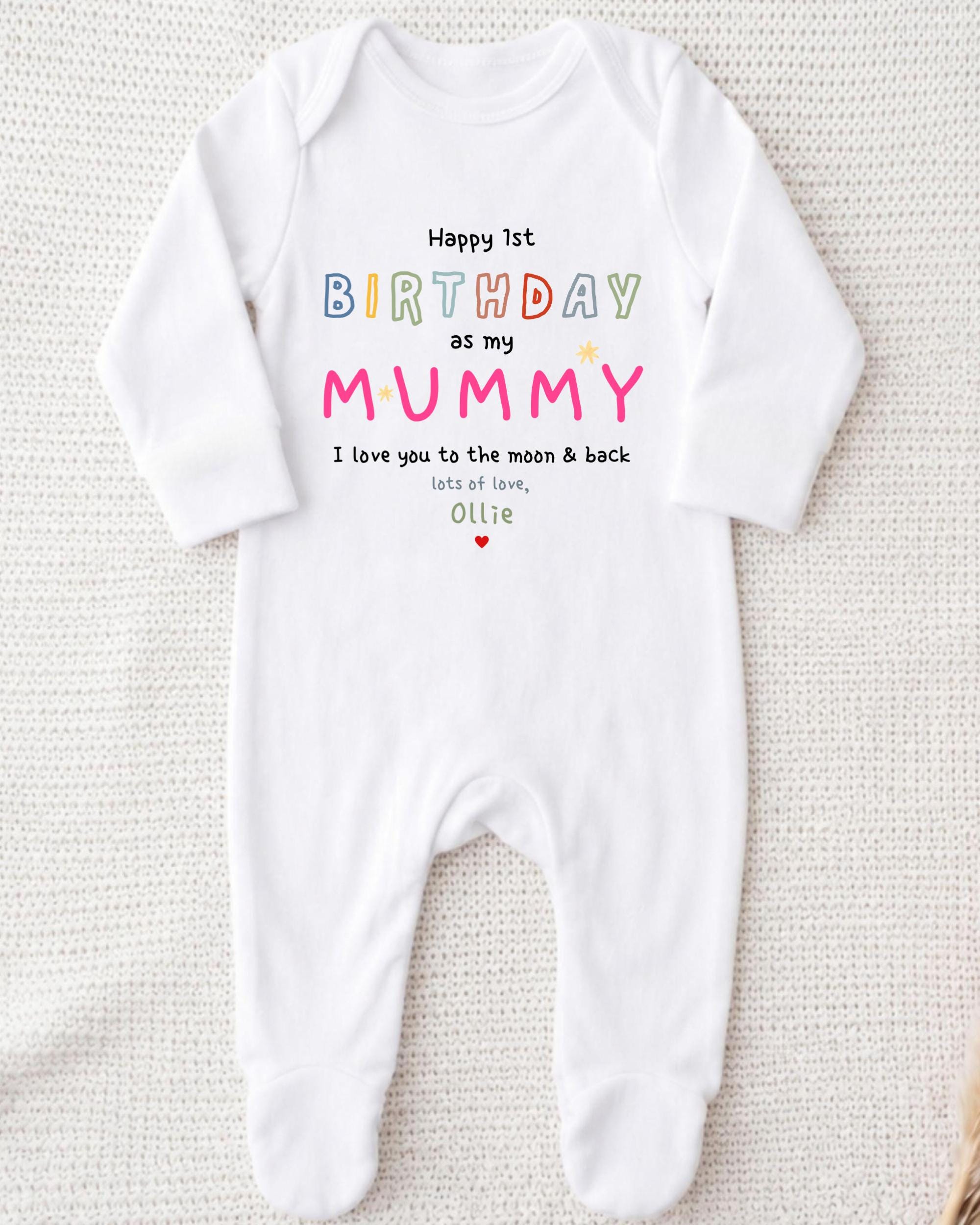 A white onesie with a personalized birthday message for a baby.