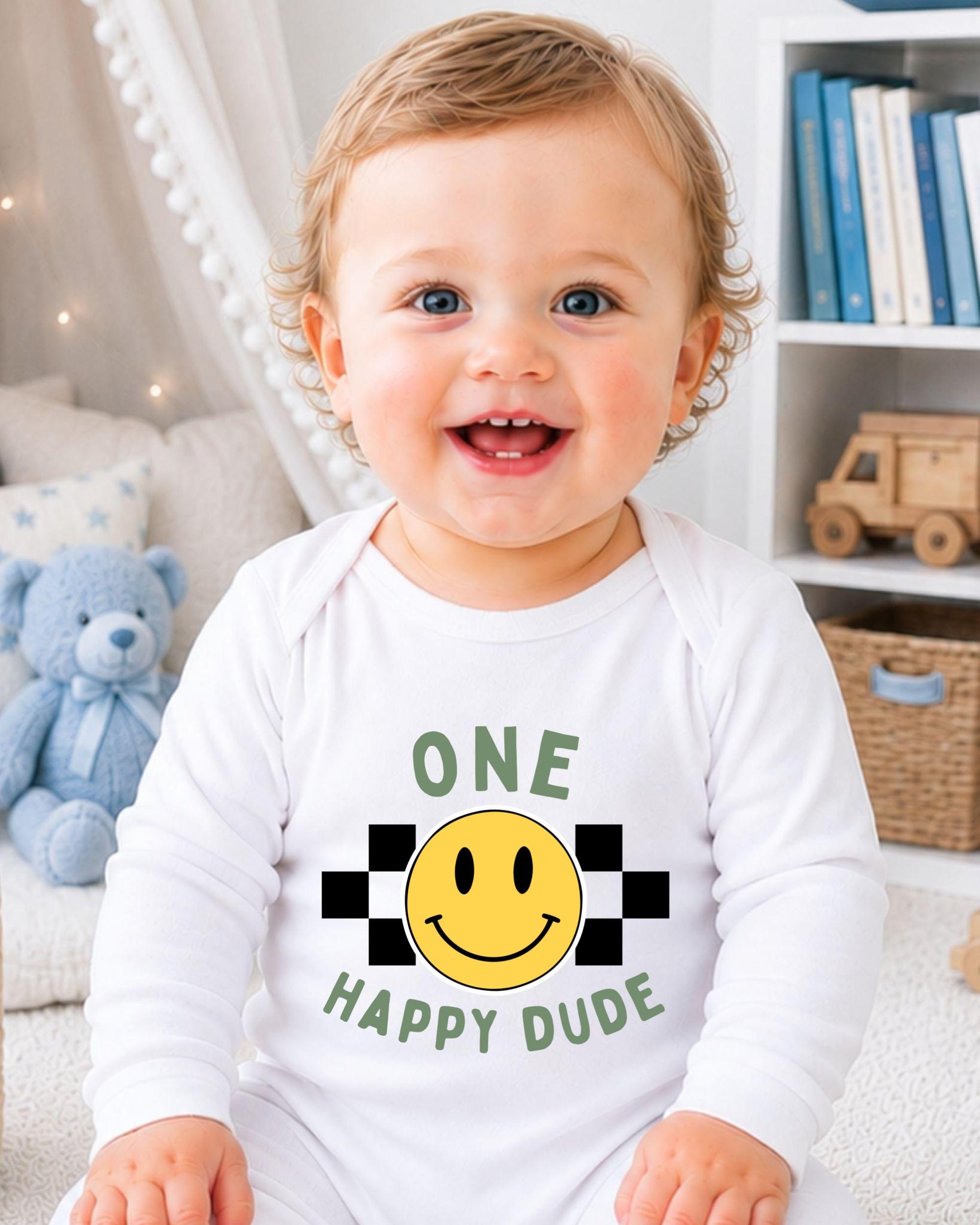 A smiling baby wearing a white onesie with a smiley face and the text "Happy Dude" printed on it.