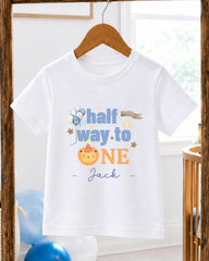 A white t-shirt with a personalized message printed on it, hanging on a wooden hanger.