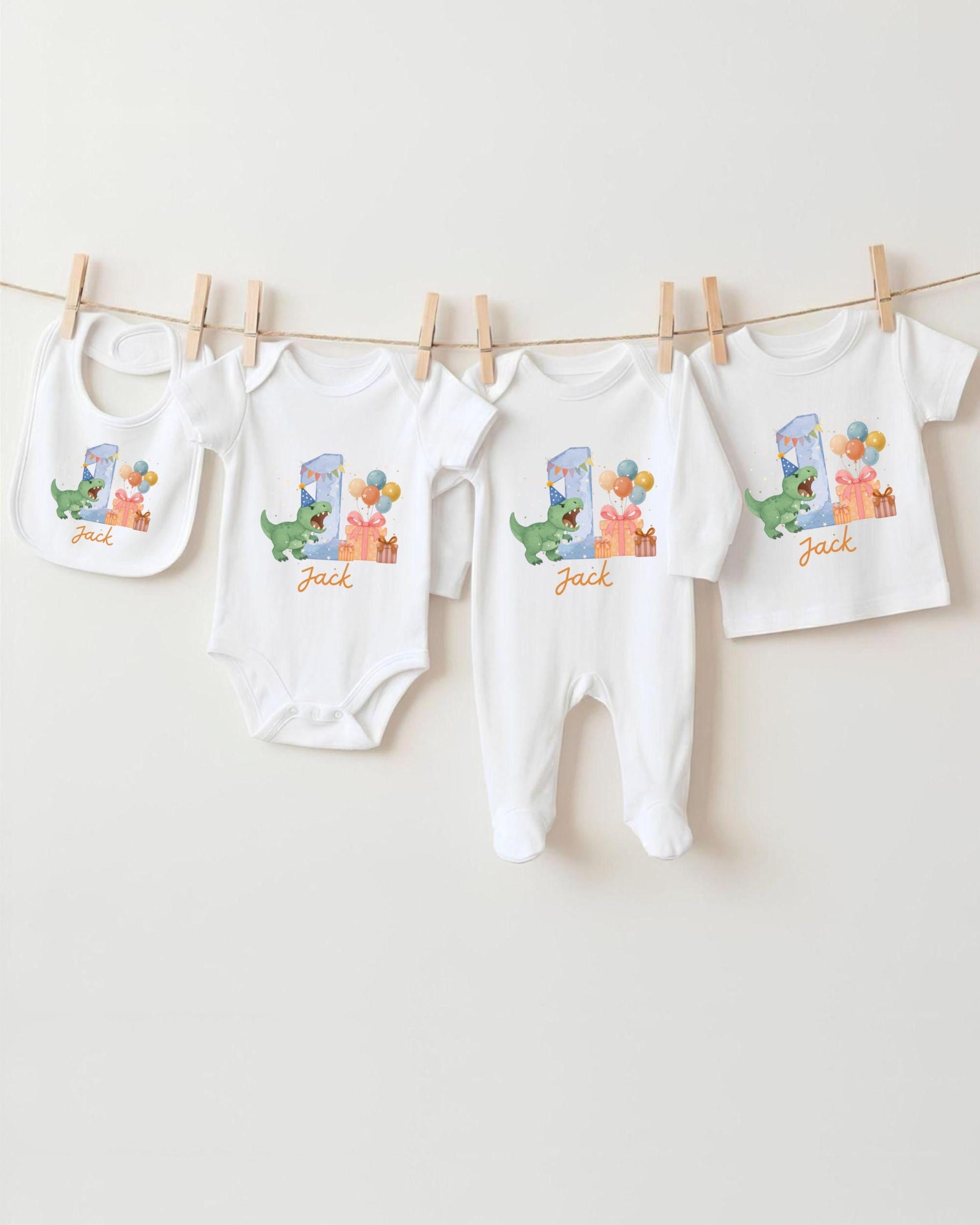 A collection of baby clothes, including onesies and bibs, hanging on a clothesline.