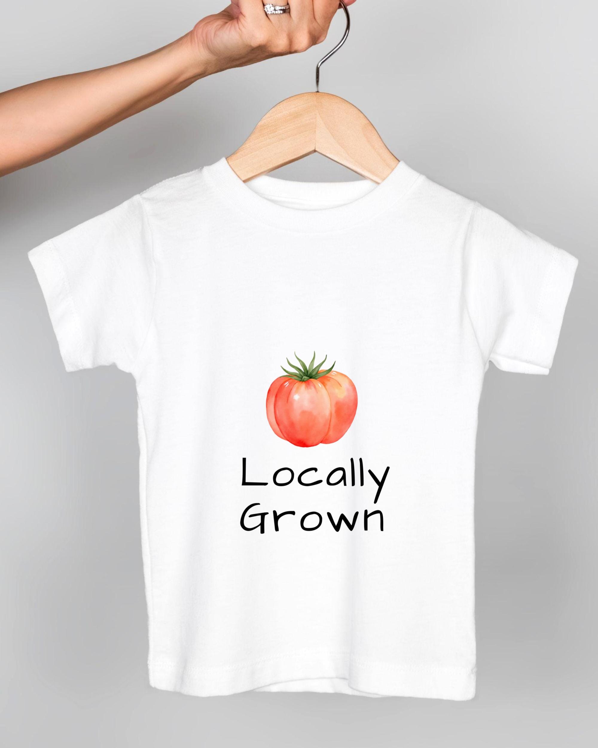 A white t-shirt with a printed design of a tomato and the text "Locally Grown" printed on it.