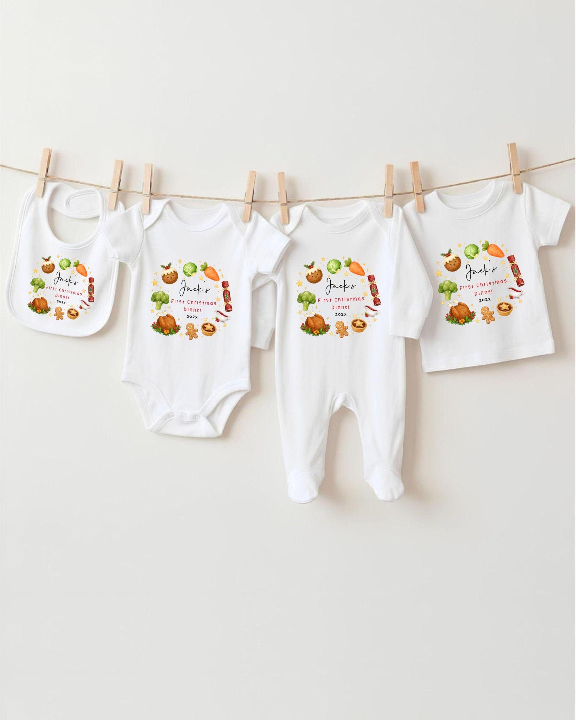 A row of four white baby clothes, including onesies and pajamas, hanging on a clothesline.