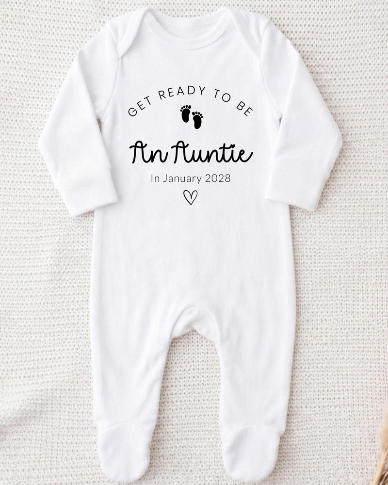 A white bodysuit with the text "Get ready to be An Auntie" printed on it, along with a heart symbol and the date "In January 2028".