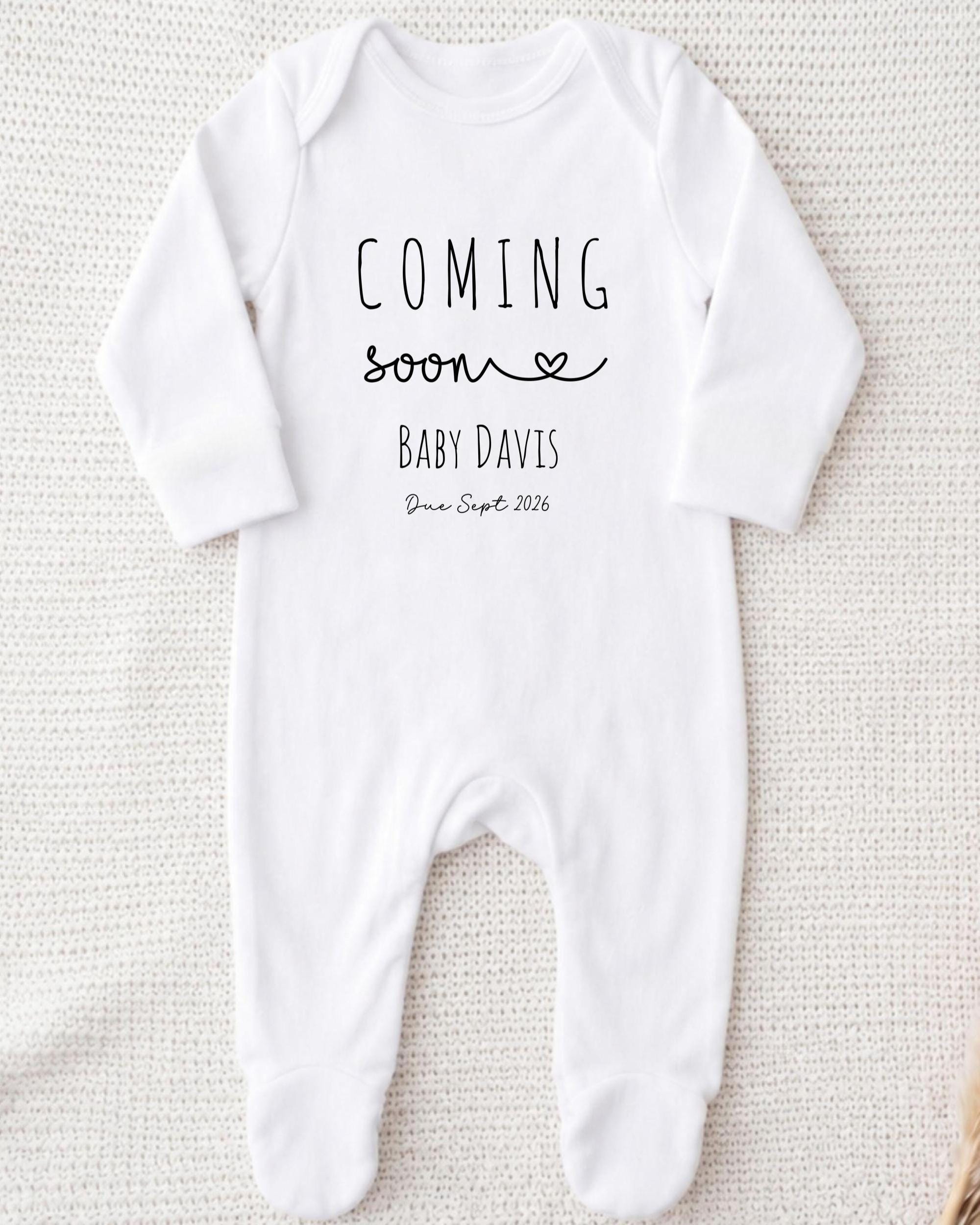 A white onesie with the text "COMING soon BABY DAVIS Due Sept 2016" printed on it.