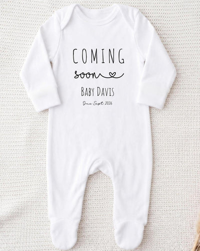 A white bodysuit with the text "COMING soon BABY DAVIS Due Sept 2016" printed on it.